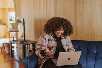 a woman sitting on a couch with a laptop computer